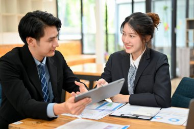 Ofiste birlikte çalışan iki Asyalı iş arkadaşı. Erkek ve kadın finans danışmanı finansal iş planlarını tartıştılar.