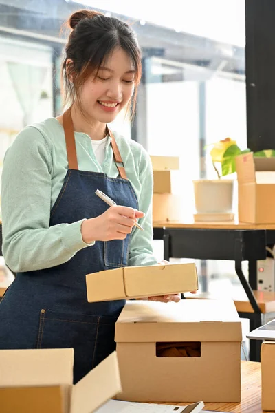 Portre, Millennial 'ın kadın girişimi e-ticaret atölyesi sahibi siparişlerini karton bir kutuya koyup müşterilere göndermeye hazır.. 