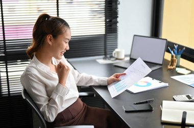 Başarılı Asyalı iş kadını finansal projesinden memnun, iş hedefini arşivliyor.