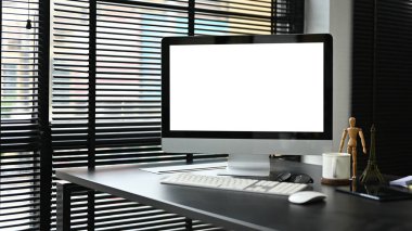 Ofis odasındaki modern karanlık ofis masasında bilgisayar beyaz ekran modeli. Modern ofis çalışma alanı resmi.
