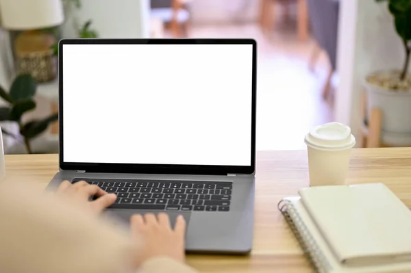 Back-view, Businesswoman using laptop computer, typing on keyboard, searching some information on the internet. Laptop white screen mockup. close-up image