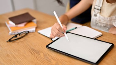 Yakından bakınca resim çizmek için tablet dokunmatik ped kullanan güzel bir kız çevrimiçi ödev yapıyor, oyun oynuyor. Tablet beyaz ekran modeli