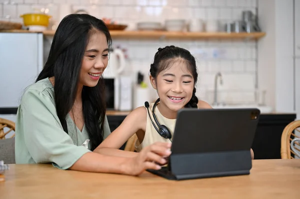 Vakker Asiatisk Mor Nydelig Datter Som Sitter Spisestuen Ser Nettbrett – stockfoto