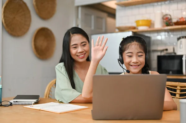 아시아인 소녀가 온라인 수업을 엄마와 집에서 노트북 컴퓨터를 배우고 있습니다 — 스톡 사진