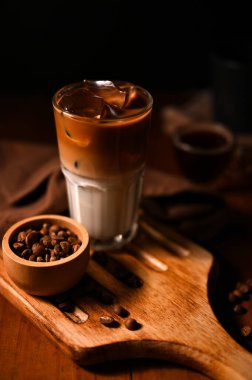 Tahta tahtada servis edilen bir bardak buzlu latte. Taze sütlü buzlu kahve. Kafe içecek konsepti