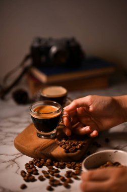 Bir bardak espresso içen bir kadın el. Yakın çekim görüntü, koyu kahve, espresso shot, kafein içecekleri.