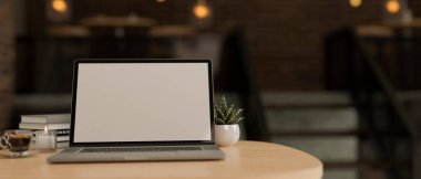 Arka plandaki bulanık ve rahat kahve dükkanının üzerinde dizüstü bilgisayarlı boş ekran, dekor bitkisi, kitap, kahve fincanı ve mum bulunan uzaktan çalışma alanı modeli. 3d görüntüleme, 3d illüstrasyon