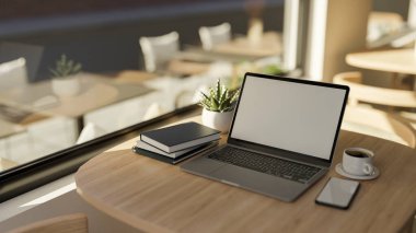 Dizüstü bilgisayarı, akıllı telefonu, yuvarlak ahşap masa üzerinde bir fincan kahve, kitap ve dekor bitkisi olan minimal konforlu kafe iç tasarımı. yakın plan, 3D görüntüleme, 3d illüstrasyon