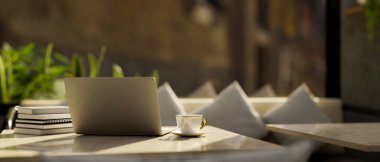 Laptop bilgisayar ve aksesuarlar arkadaki lüks ve rahat restoran kanepesinin üzerinde modern mermer bir masa üzerinde. Arkadan bak. 3d görüntüleme, 3d illüstrasyon