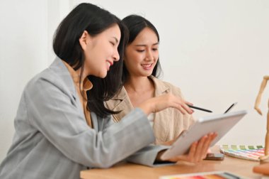 Takım çalışması konsepti. Ofiste birlikte çalışan iki Asyalı iş kadını beyin fırtınası ve planlama birlikte çalışıyor..