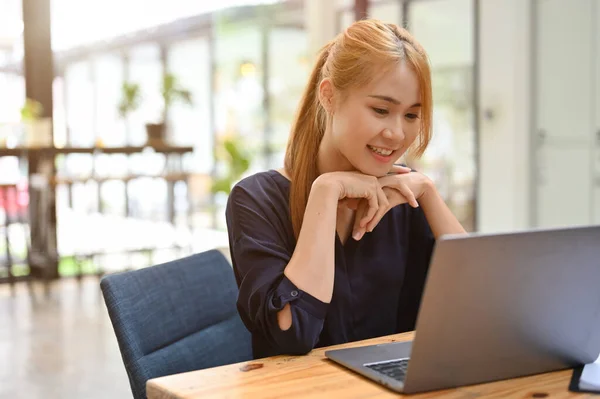 Attractive and gorgeous asian woman remote working at the coffee shop. Businesswoman using laptop computer, doing her project assignment in the cafe.