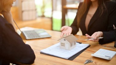 Bayan emlakçı ofiste potansiyel bir müşteriyle görüşüyor. Kira, Alım, İpotek Emlak Konsepti. yakın plan ve kırpılmış resim