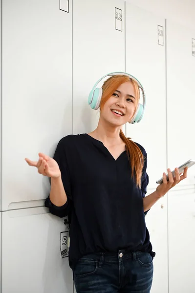 Portrait of a Carefree and joyful asian millennial woman listening to the music the modern headphones.