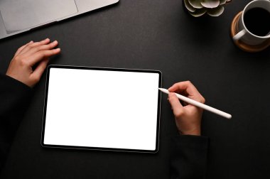 Elinde bir stil kalem tutan ve dijital tablet dokunmatik kağıdına resim çizen bir kadın modern siyah ofis çalışma alanında beyaz ekran modeli. en üstteki görünüm