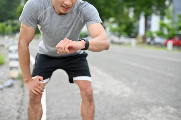 Agotado Asiático Atleta Masculino Manos Rodilla Comprobando Ritmo Cardíaco Smartwatch — Foto de Stock