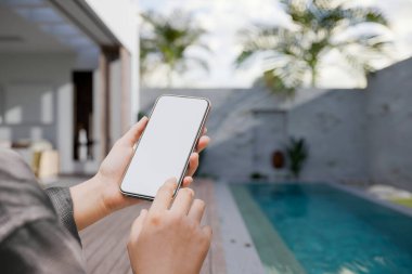 Kadınların elindeki akıllı telefon ekranının bir kopyası arka planda yüzme havuzu olan güzel bir bilardo villası üzerinde. 3d görüntüleme, 3d illüstrasyon