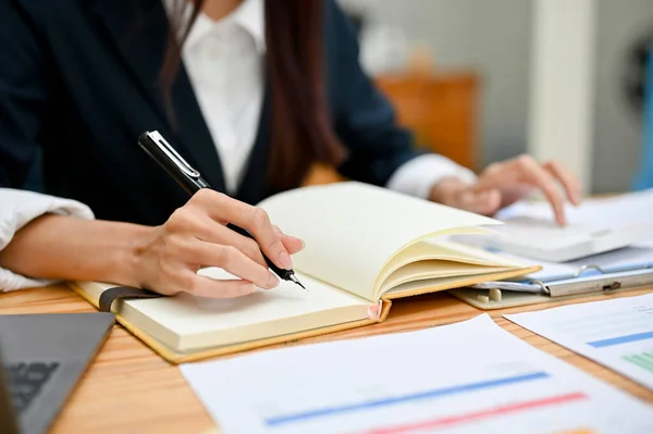 Businesswoman Working Her Office Desk Analysing Financial Data Taking Notes Stock Photo