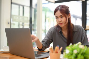 Yaratıcı çalışma alanında çalışan güzel Asyalı kadın grafik tasarımcısı. Dizüstü bilgisayar kullanan kadın ofis çalışanı.
