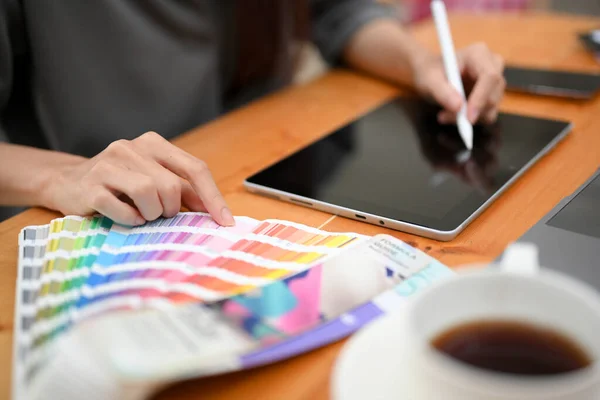 Female graphic designer using digital graphic tablet touchpad with stylus pen, sketching her design. cropped image