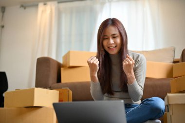 Başarılı genç Asyalı kadın çevrimiçi dükkan sahibi ya da küçük işletme girişimcisi alışveriş sitesindeki satış siparişiyle şaşkına döndü..