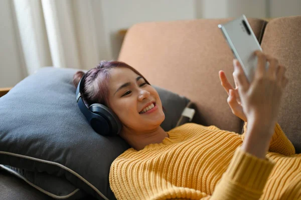 Красива Азіатська Жінка Тисячоліття Лежить Зручному Дивані Слухає Музику Носить — стокове фото