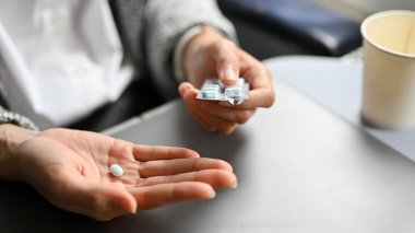Yakın plan görüntü, kadın elinde uçak tutması hapı. Sağlık ve ulaşım kavramı.