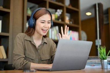 Oldukça çekici bir Asyalı kadın serbest öğretmen öğrencilerine online bilgisayar platformu üzerinden ders veriyor..