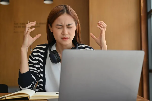 Beautiful young asian woman college student using laptop computer, feeling stress and serious on her project.