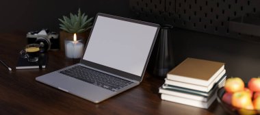 Yakın plan görüntü, taşınabilir dizüstü bilgisayar, beyaz ekran maketi, kara tahta masanın üzerindeki kitap yığını ve aksesuarlar. Modern çalışma alanı. 3d görüntüleme, 3d illüstrasyon