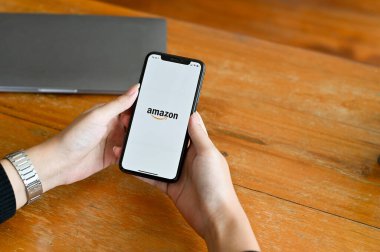 Chiangmai, Tayland - 29 Haziran 2022: Akıllı telefonda Amazon uygulaması kullanan bir kadın. Amazon alışveriş uygulaması geçmişine sahip bir akıllı telefon modeli.