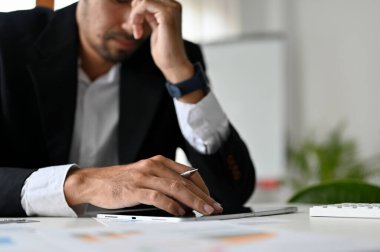 Stresli ve başarısız Asyalı iş adamı ya da masasında çalışan erkek yönetici. Düşünceli erkek yönetici iş cirosundan dolayı üzgün. kırpılmış resim