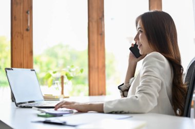 Çekici genç yetişkinler, Asyalı iş kadını ya da bayan yönetici ofis tedarikçisi ile telefonda konuşuyor..