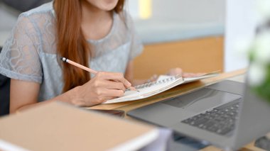 Güzel Asyalı bayan üniversite öğrencisi ya da görevi üzerinde çalışan ve dizüstü bilgisayar kullanan kadın ofis çalışanı. kırpılmış resim