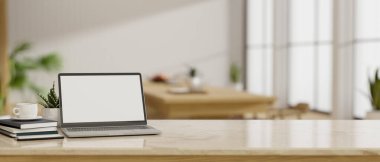 Dizüstü bilgisayarın beyaz ekran maketi, aksesuarlar ve fotokopi alanı arka planda bulanık minimal yemek odası üzerinde. 3d görüntüleme, 3d illüstrasyon