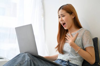 Genç Asyalı kadının oturma odasında dizüstü bilgisayar kullanmasına şaşırmış ve şaşırmıştı. Beklenmedik bir e-posta ya da haber alıyordu..