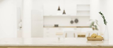 Modern kitchen tabletop or countertop with a bread basket, ceramic vase and copy space for your product display over blurred modern bright kitchen in the background. 3d rendering, 3d illustration
