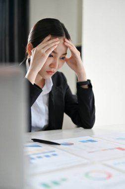 Stresli ve ciddi Asyalı iş kadını ya da kadın finans danışmanı finansal bir rapor okuyor, iş için finansal bir plan düşünüyor..