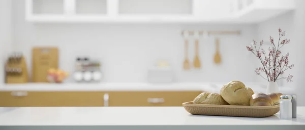 White kitchen tabletop with a bread basket, flowers vase and copy space for montage your product display over blurred minimal kitchen cooking space in background. 3d rendering, 3d illustration