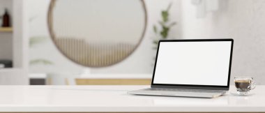 Minimum beyaz çalışma masası, dizüstü beyaz ekran maketi, bir fincan kahve ve arka plandaki bulanık oturma odasındaki ürün serginiz için kopya alanı. 3d görüntüleme, 3d illüstrasyon