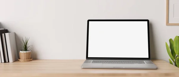 Minimal working desk with opened notebook laptop white screen mockup, book, and decor plants over white wall. 3d rendering, 3d illustration