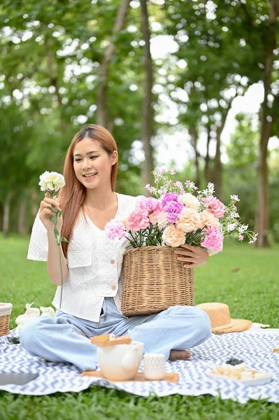 Attractive Millennial Asian Female Picnicking Green Park Holding Beautiful Flower — Fotografia de Stock