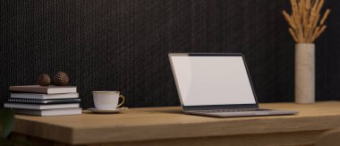 Trendy workspace with portable notebook laptop white screen mockup, coffee cup, book and dried flowers vase on wooden table against the black wall. 3d rendering, 3d illustration