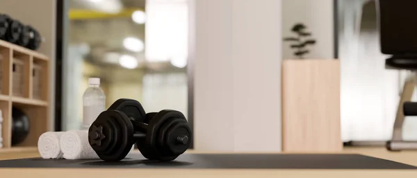 Dumbbells, towels and a bottle of water on a exercise mat over blurred modern fitness gym in the background. close-up image. 3d rendering, 3d illustration