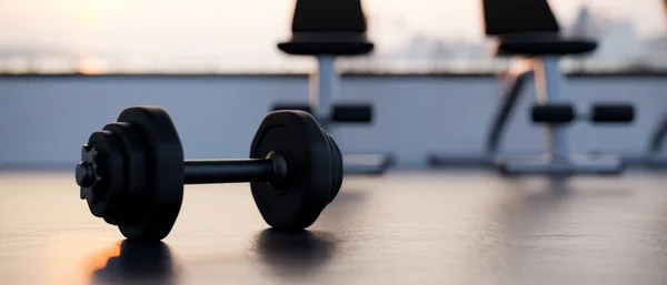 Dumbbell is on a gym floor over blurred modern fitness gym in the background. close-up image, sport fitness equipment. 3d rendering, 3d illustration