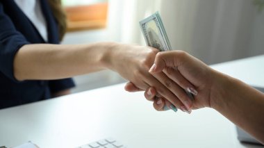 Close-up image, Two businesspeople were in the secret meeting, shaking hands and trying to secretly pass money or bribes.
