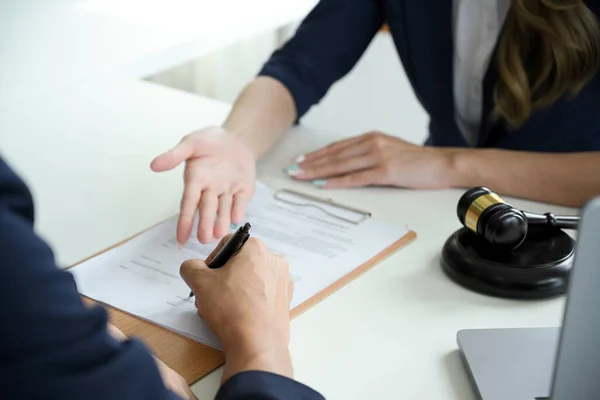 A professional female lawyer or legal consultant having a meeting with client to sign the agreement contract. cropped and close-up hands image