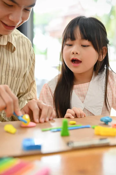 Portrait, Kind and happy Asian dad and girl playing at home, moulding colorful clay or plasticine together. Happy family time concept