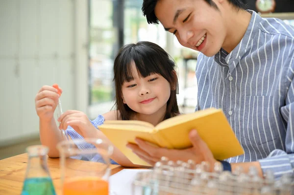Bright Little Asian Girl Concentrating Learning Science While Her Teacher — Stockfoto