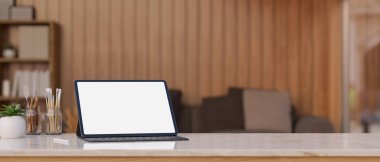 Portable digital tablet white screen mockup with wireless keyboard, tablet pen, painting tools and copy space on tabletop over blurred living room in background. 3d rendering, 3d illustration