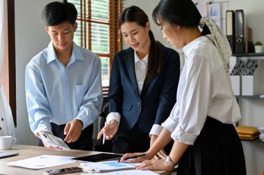 Group of an Asian businesspeople working together, planning and brainstorming financial investment strategy together.
